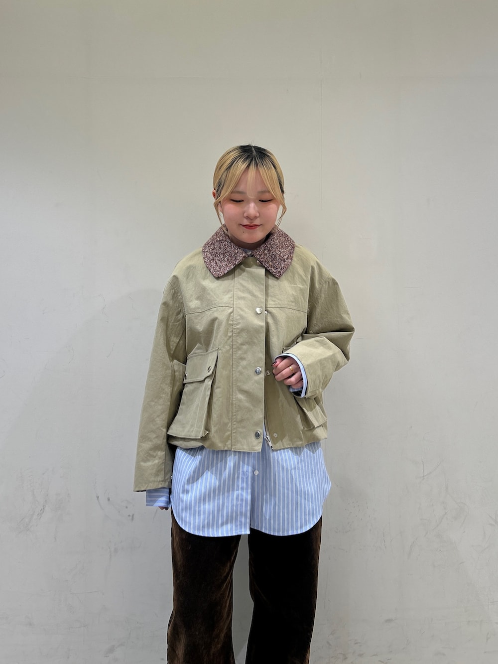 ベージュ系のブルゾン、ブルー系のシャツ/ブラウス、ブラウン系のデニムパンツを着用したレディースの冬コーディネートの5枚目の写真