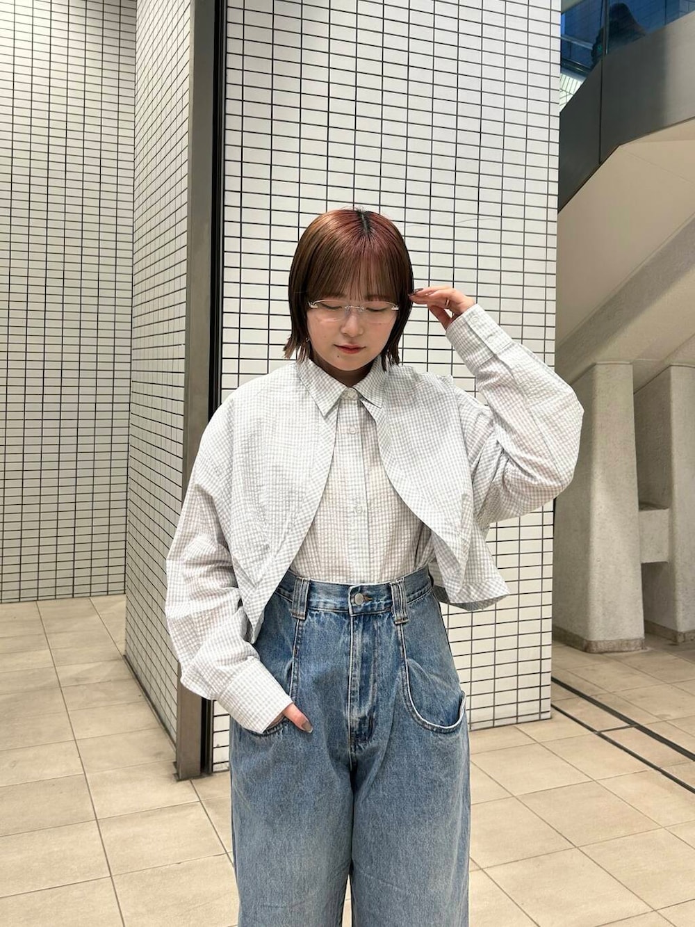 ブルー系のデニムパンツ、ブラック系のスニーカー、レッド系のショルダーバッグを着用したレディースの冬コーディネートの8枚目の写真