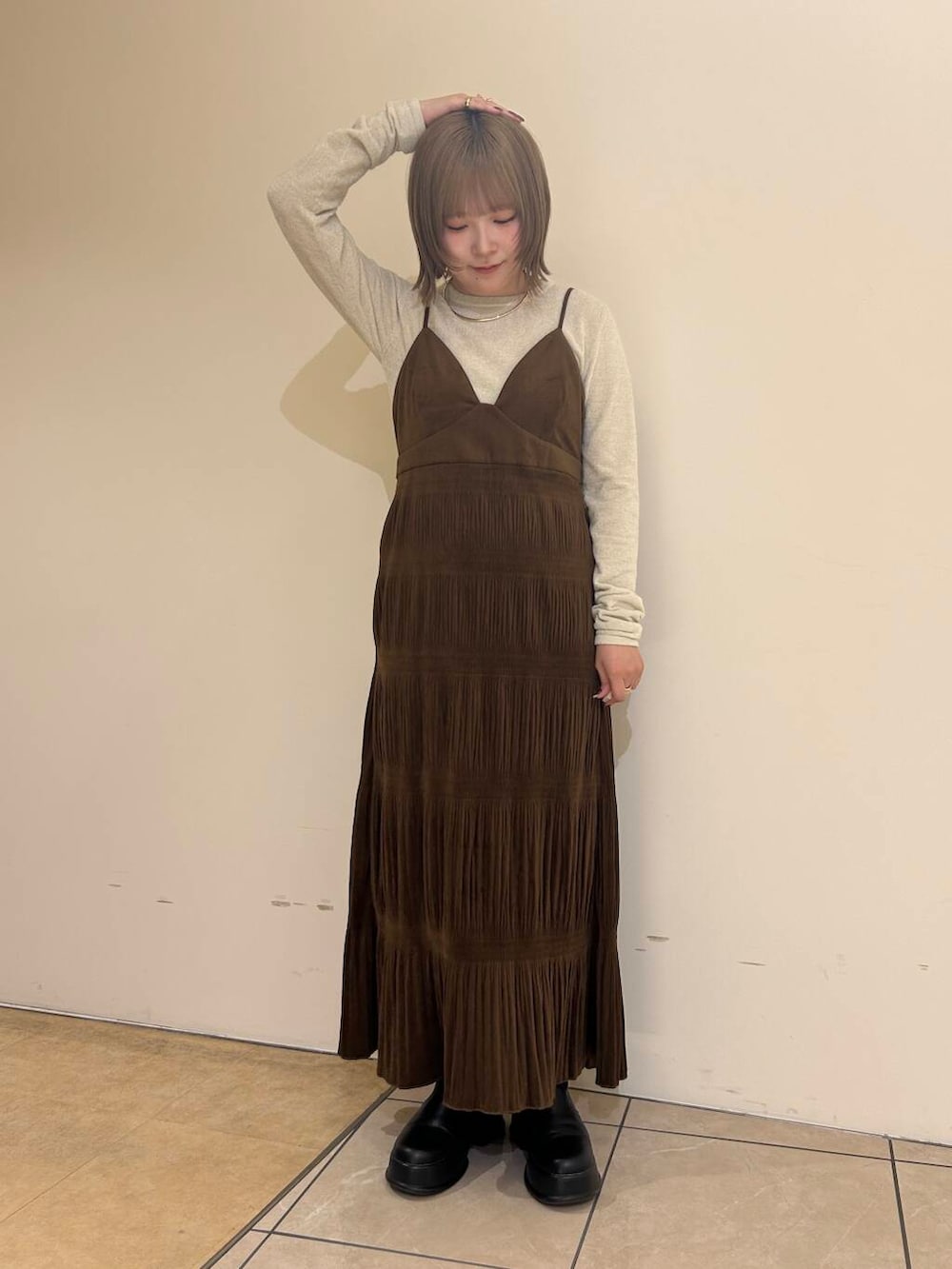 ホワイト系のダウンジャケット/コート、ブラウン系のワンピース、ホワイト系のニット/セーターを着用したレディースの冬コーディネートの6枚目の写真