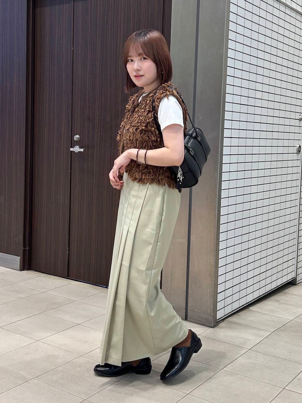 ホワイト系のTシャツ/カットソー、ブラウン系のベスト、ブラック系のボストンバッグを着用したレディースの夏コーディネートの3枚目の写真