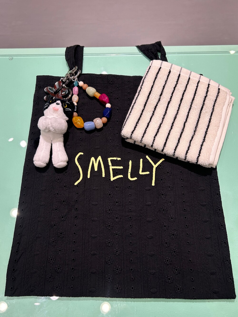 ブラック系のトートバッグ、ブラック系のキーホルダー、ブラック系のハンカチ/ハンドタオルを着用したレディースの秋コーディネートの2枚目の写真