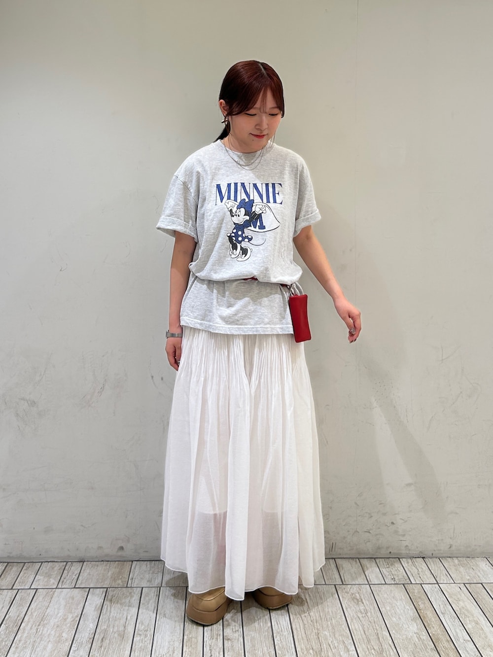 グレー系のTシャツ/カットソー、ホワイト系のスカート、シルバー系のネックレスを着用したレディースの夏コーディネートの2枚目の写真