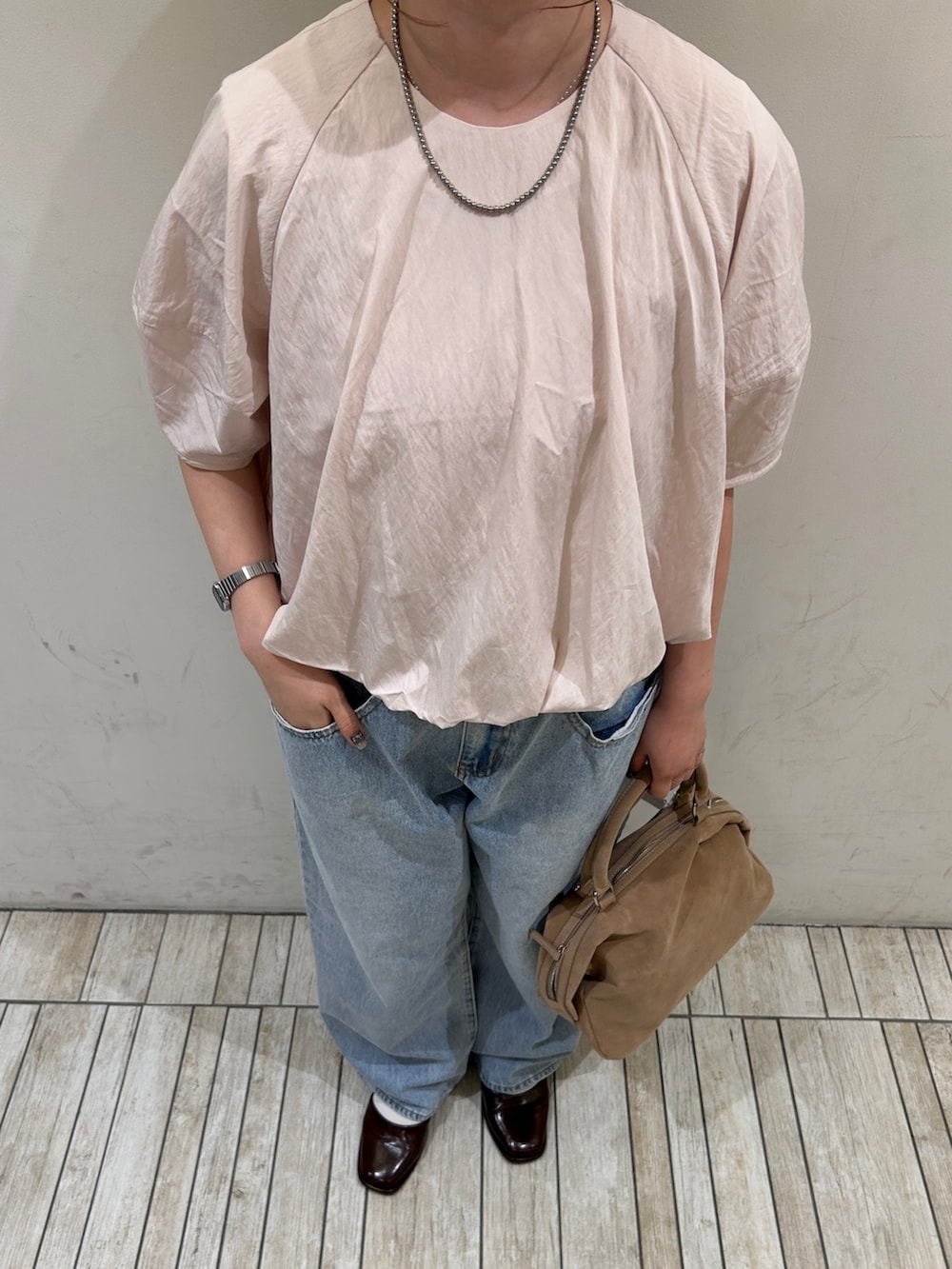 ブルー系のデニムパンツ、ベージュ系のボストンバッグ、ピンク系のシャツ/ブラウスを着用したレディースの夏コーディネートの2枚目の写真