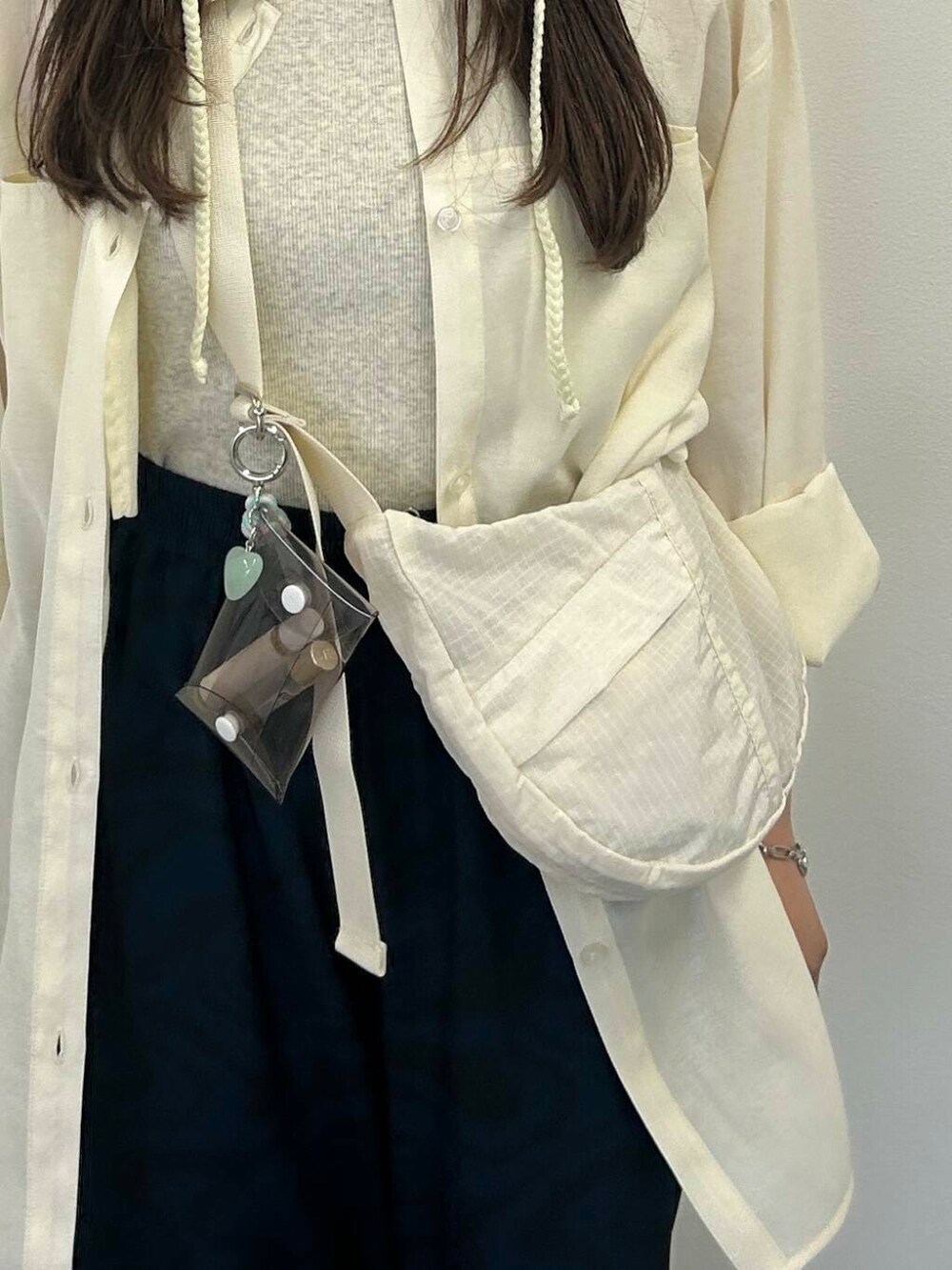 グレー系のタンクトップ、ホワイト系のシャツ/ブラウス、ブルー系のその他パンツを着用したレディースの夏コーディネートの3枚目の写真