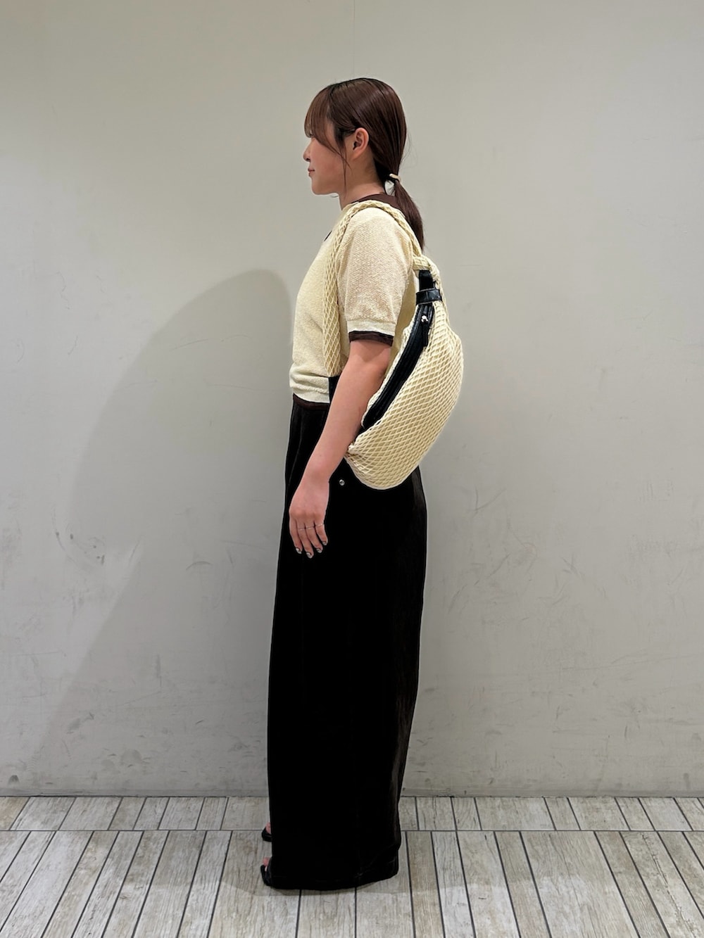 イエロー系のニット/セーター、ブラウン系のその他パンツ、ブラック系のサンダルを着用したレディースの夏コーディネートの2枚目の写真