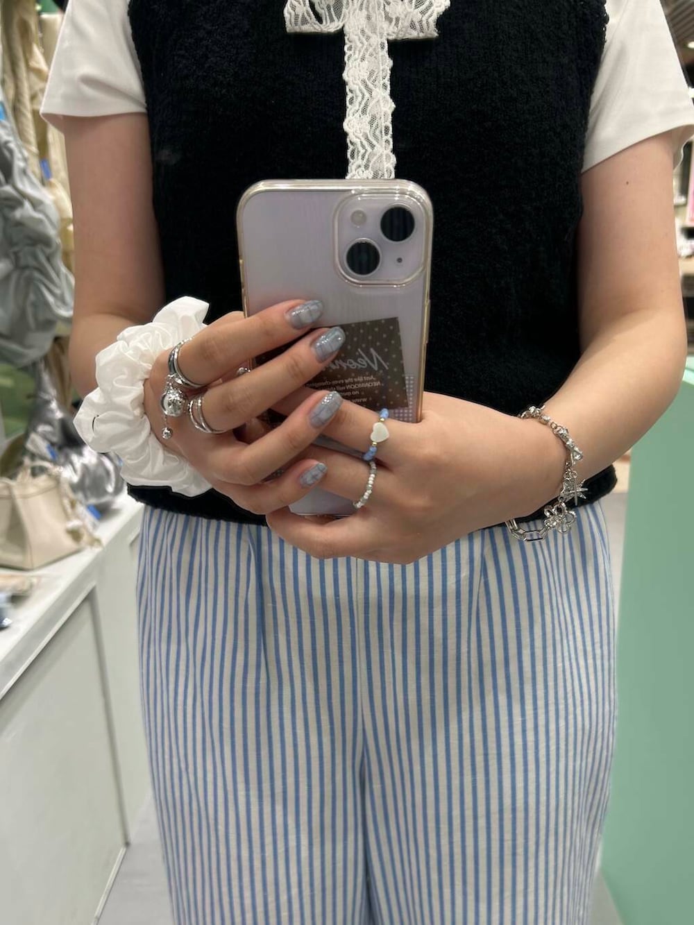 ブラック系のニット/セーター、シルバー系のブレスレット、ホワイト系のヘアゴムを着用したレディースの夏コーディネートの3枚目の写真