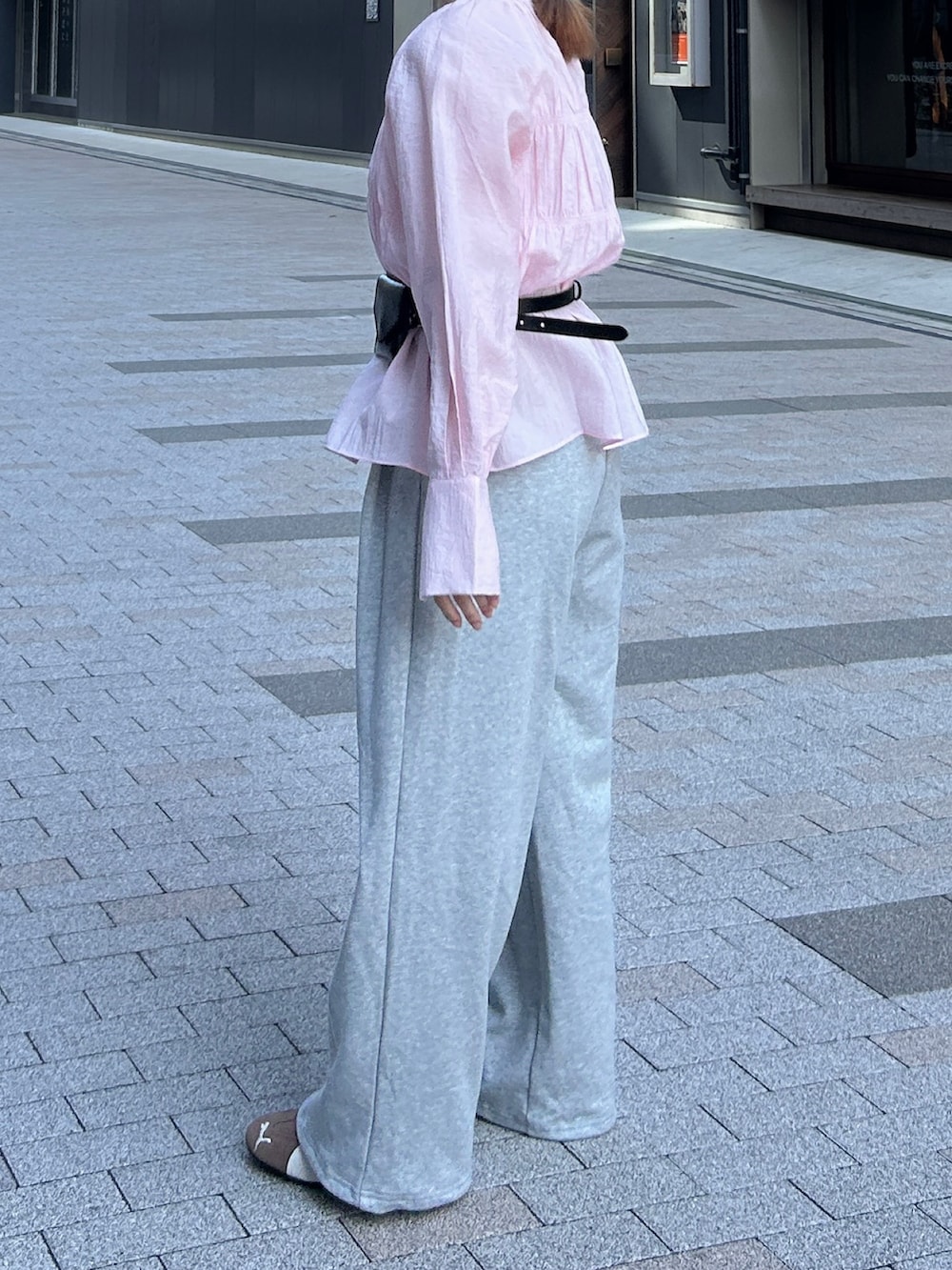 ピンク系のシャツ/ブラウス、グレー系のその他パンツ、ブラック系のハンドバッグを着用したレディースの春コーディネートの5枚目の写真