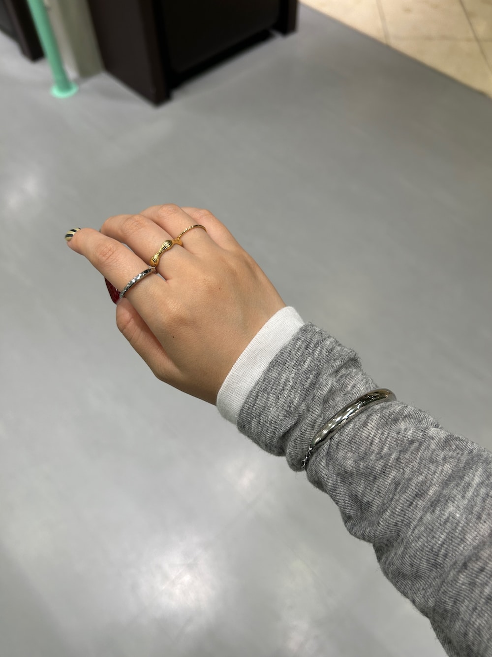 ブラック系のスニーカー、ブラウン系のスカート、ゴールド系のキーホルダーを着用したレディースの秋コーディネートの5枚目の写真