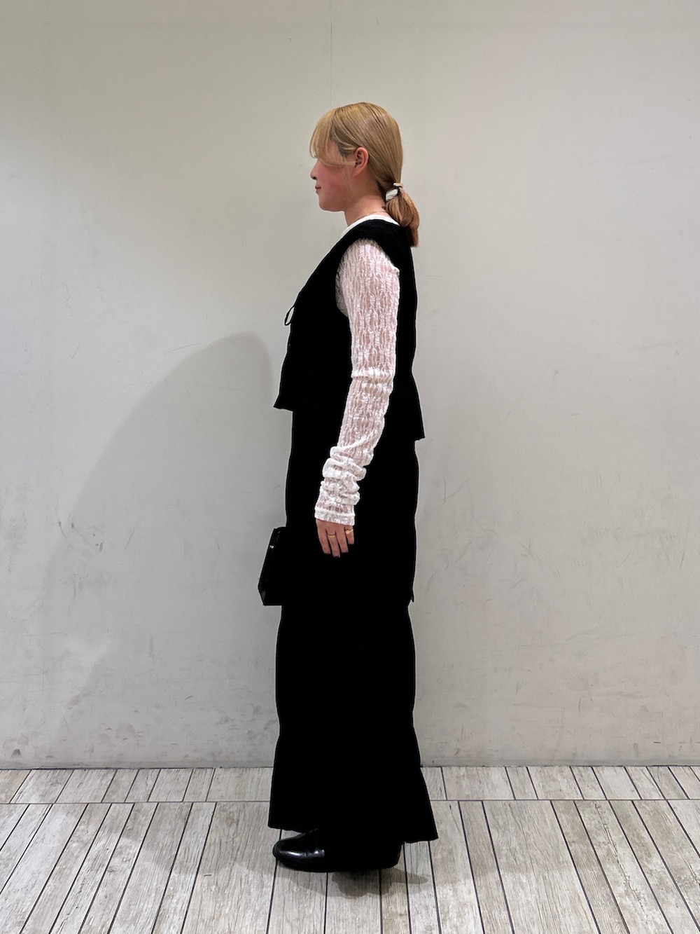 ブラック系のセットアップ、ホワイト系のTシャツ/カットソー、ブラック系のボストンバッグを着用したレディースの春コーディネートの2枚目の写真