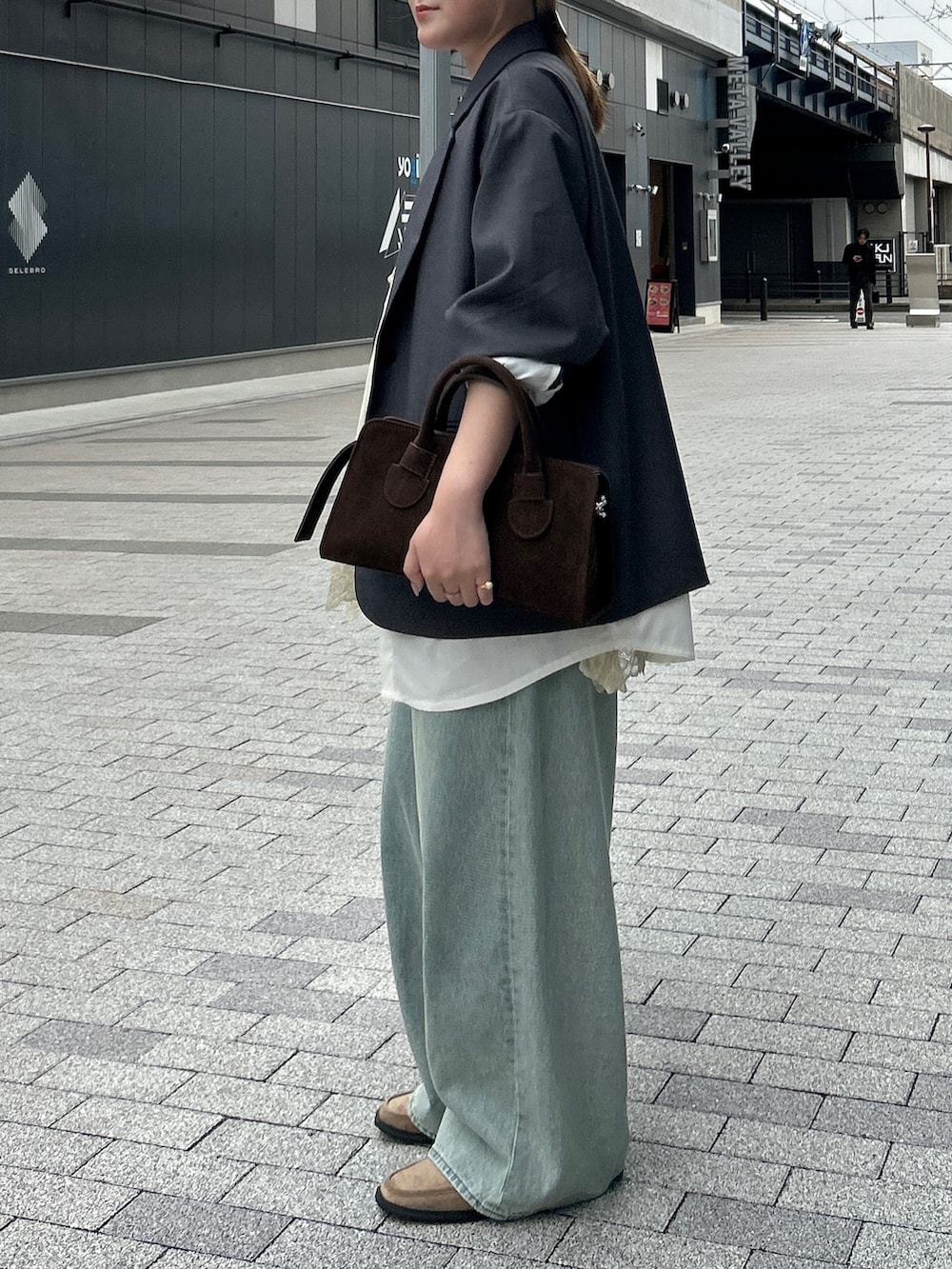 グレー系のその他アウター、ブルー系のデニムパンツ、ベージュ系のローファーを着用したレディースの春コーディネートの4枚目の写真