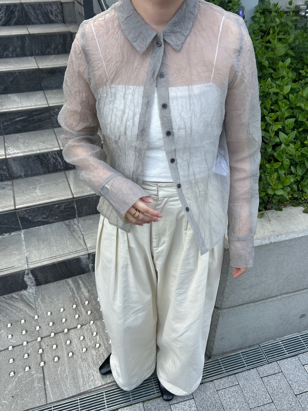 グレー系のシャツ/ブラウス、ホワイト系のその他パンツ、ブラック系のパンプスを着用したレディースの春コーディネートの6枚目の写真