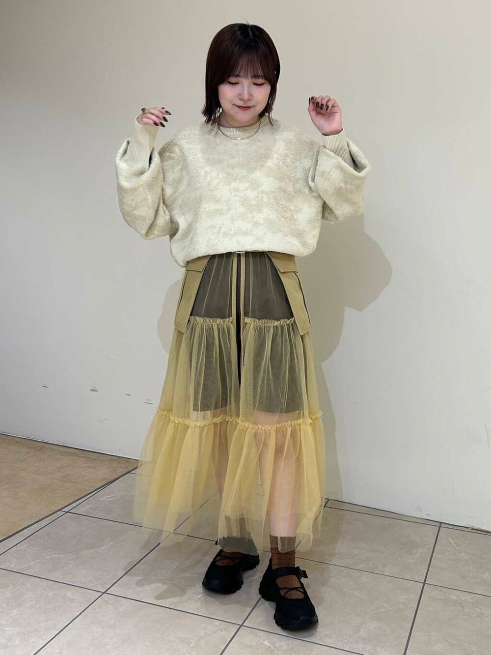 ブラック系のスニーカー、ベージュ系のスカート、ブラウン系のその他パンツを着用したレディースの夏コーディネートの2枚目の写真