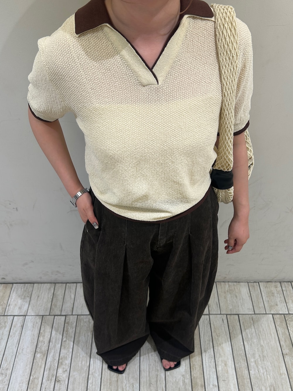 イエロー系のニット/セーター、ブラウン系のその他パンツ、ブラック系のサンダルを着用したレディースの夏コーディネートの3枚目の写真