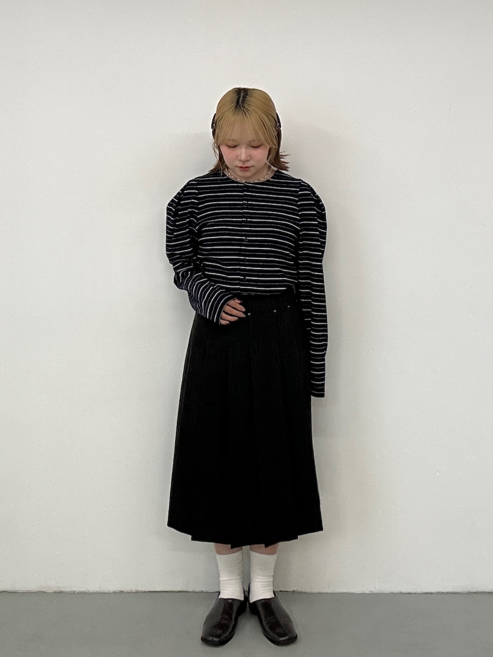 グレー系のその他シューズ、グレー系のスカート、ブルー系のカーディガン/ボレロを着用したレディースの冬コーディネートの4枚目の写真