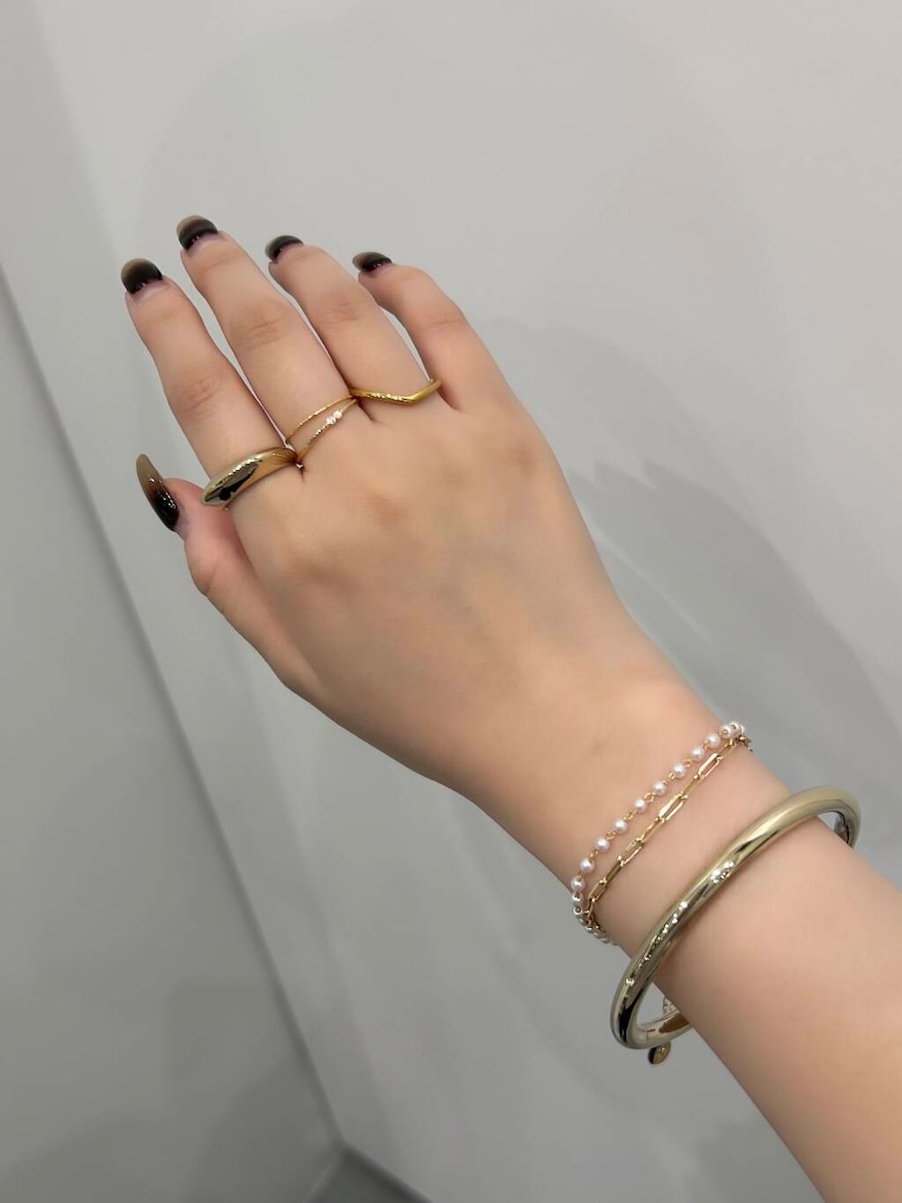 ゴールド系のリング、ホワイト系のブレスレット、ゴールド系のリングを着用したレディースの春コーディネートの2枚目の写真