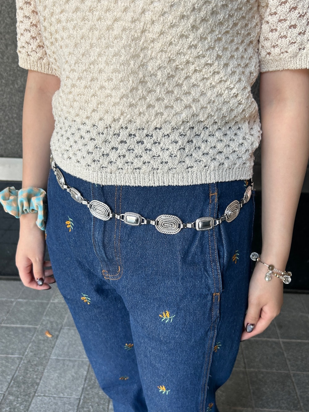 ホワイト系のニット/セーター、ブルー系のデニムパンツ、シルバー系のネックレスを着用したレディースの夏コーディネートの3枚目の写真