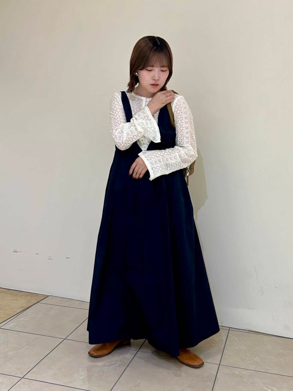 グリーン系のボストンバッグ、ブルー系のワンピース、イエロー系のその他シューズを着用したレディースの秋コーディネートの2枚目の写真