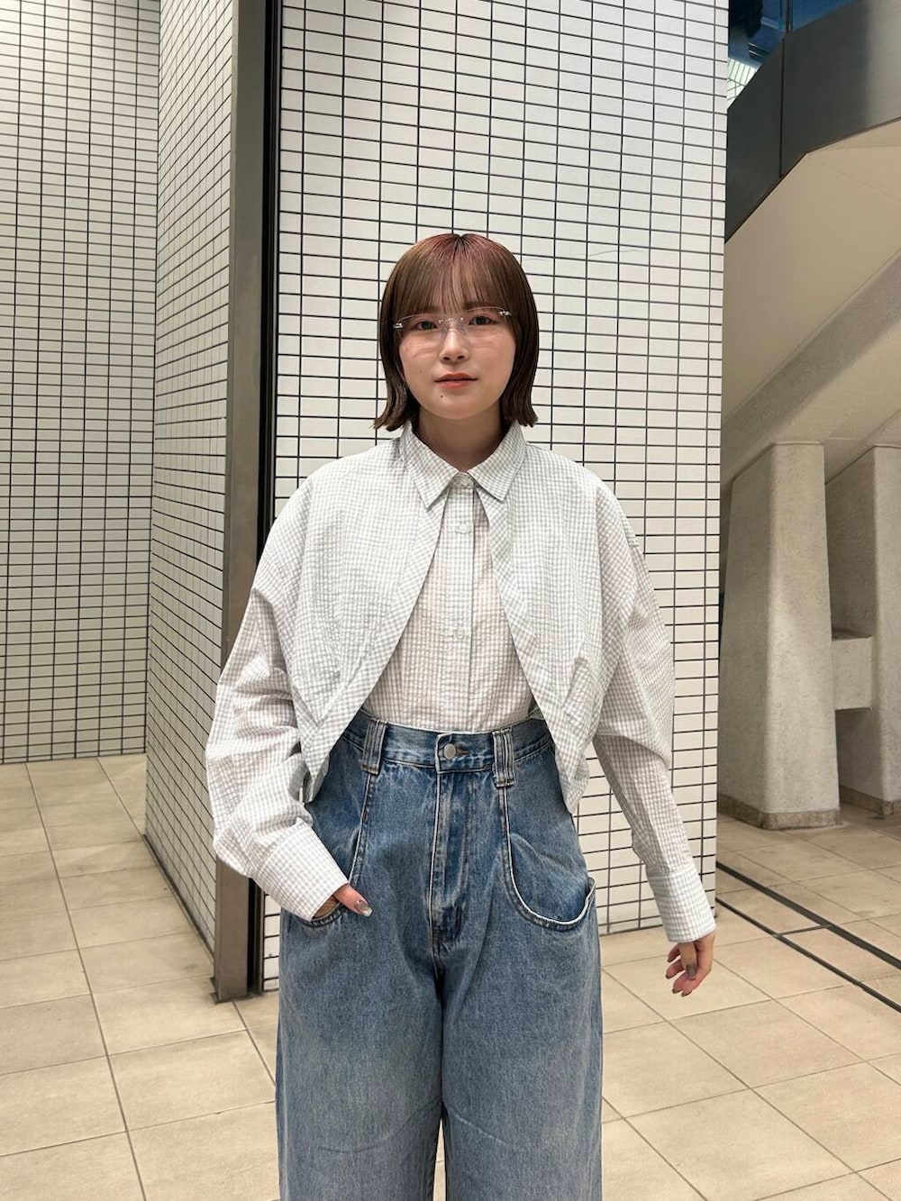 ブルー系のデニムパンツ、ブラック系のスニーカー、レッド系のショルダーバッグを着用したレディースの冬コーディネートの7枚目の写真