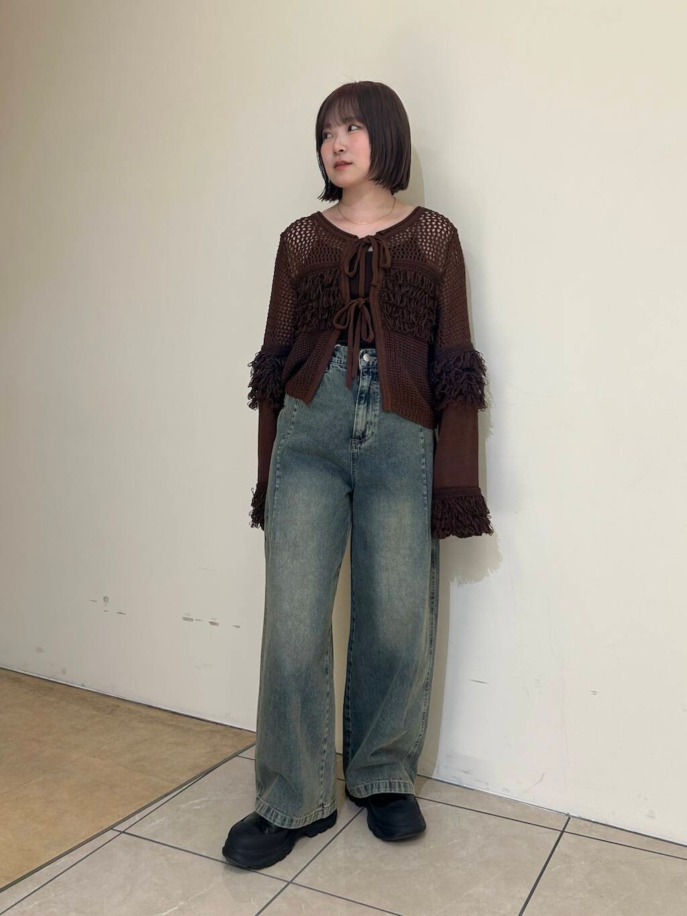 ブラック系のブーツ、ブルー系のデニムパンツ、ブラウン系のニット/セーターを着用したレディースの冬コーディネートの3枚目の写真