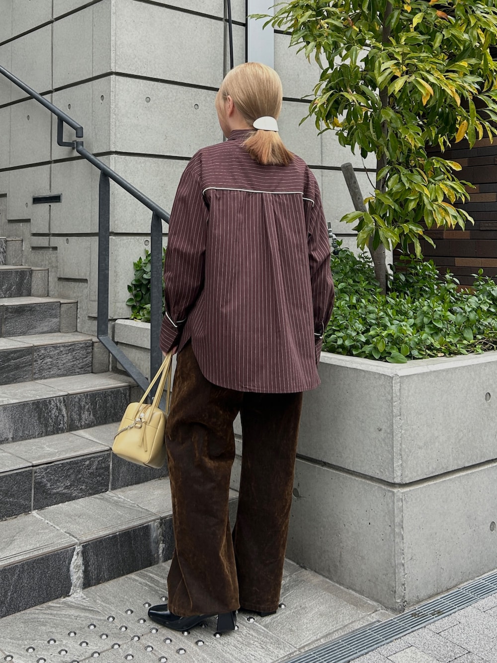 ブラウン系のシャツ/ブラウス、ホワイト系のTシャツ/カットソー、ブラウン系のデニムパンツを着用したレディースの春コーディネートの3枚目の写真