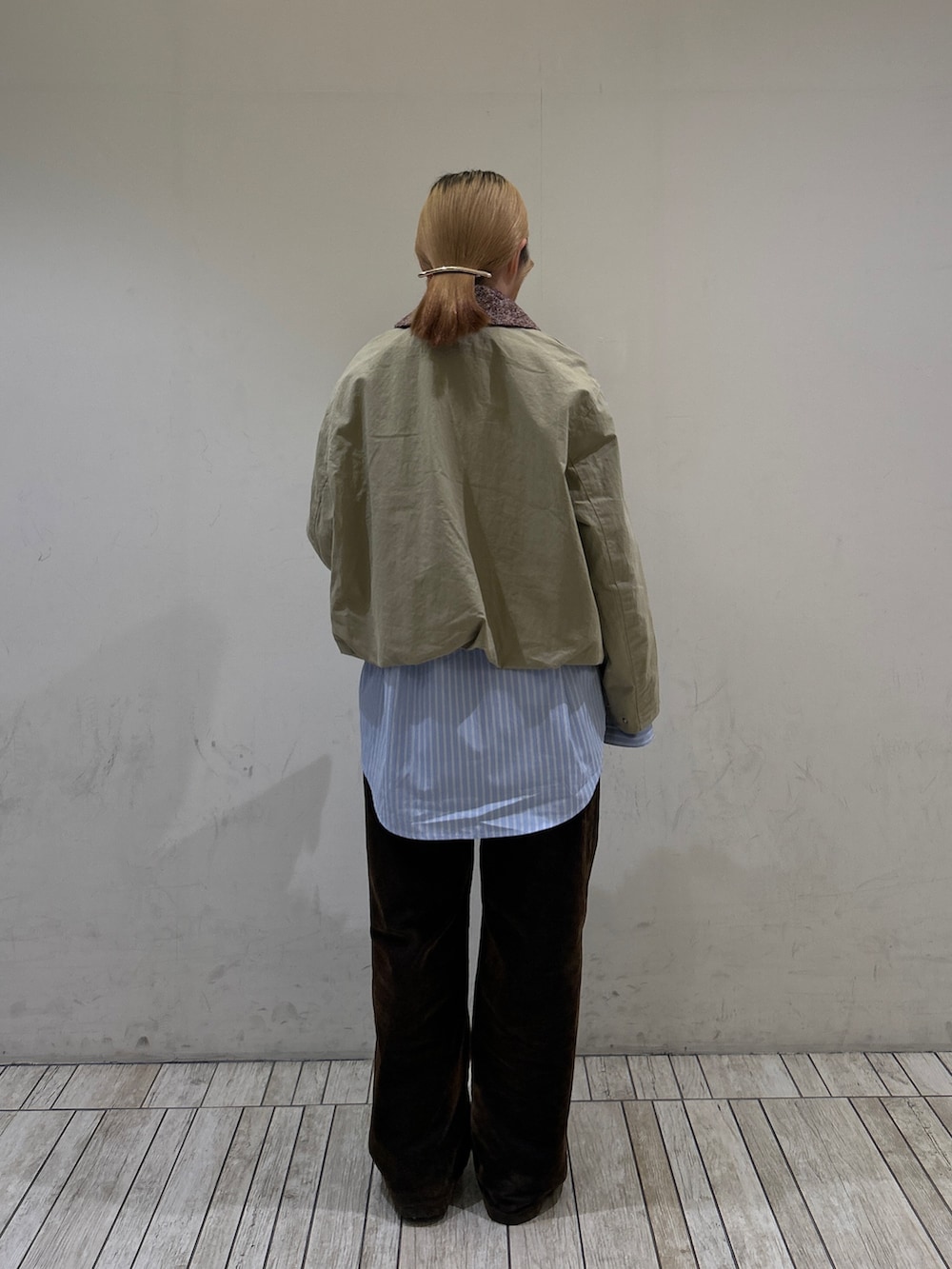 ベージュ系のブルゾン、ブルー系のシャツ/ブラウス、ブラウン系のデニムパンツを着用したレディースの冬コーディネートの4枚目の写真