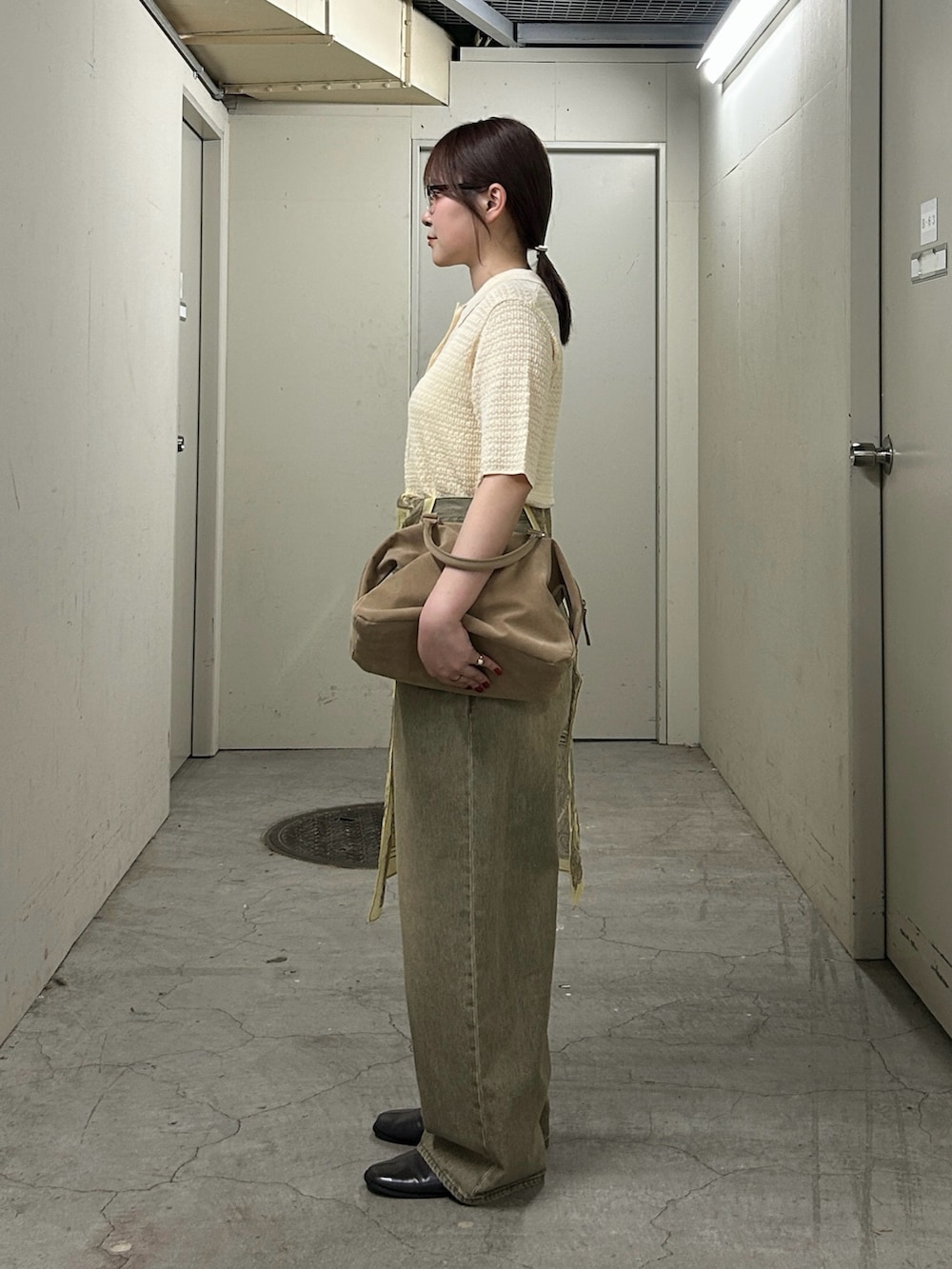 ホワイト系のニット/セーター、グリーン系のデニムパンツ、グレー系のその他シューズを着用したレディースの春コーディネートの3枚目の写真