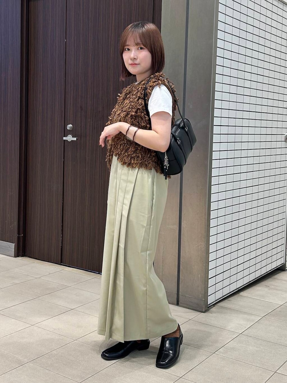 ホワイト系のTシャツ/カットソー、ブラウン系のベスト、ブラック系のボストンバッグを着用したレディースの夏コーディネートの2枚目の写真