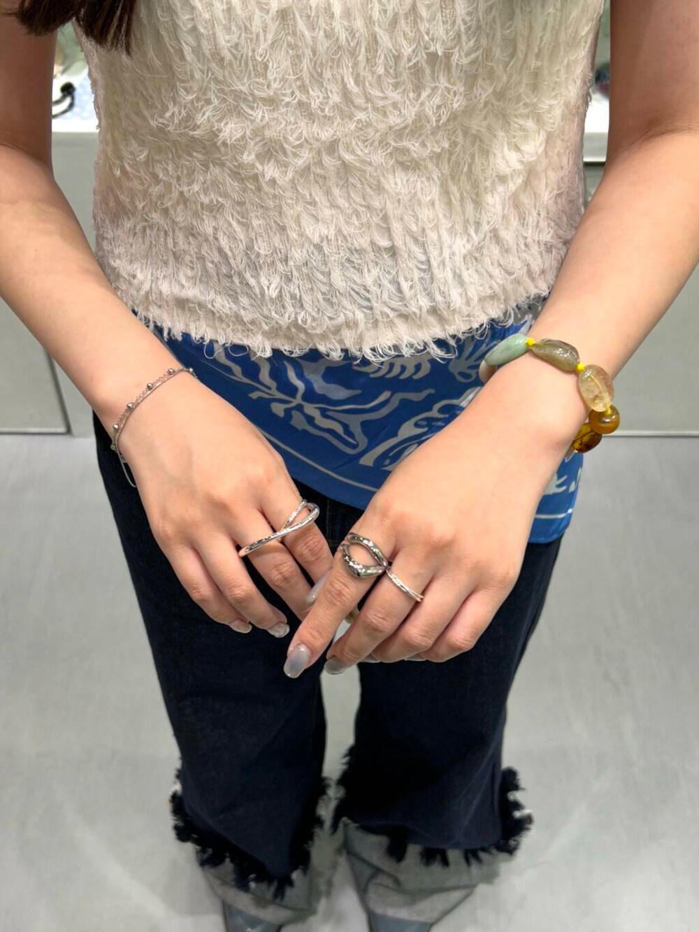 ブルー系のデニムパンツ、イエロー系のニット/セーター、シルバー系のネックレスを着用したレディースの春コーディネートの4枚目の写真