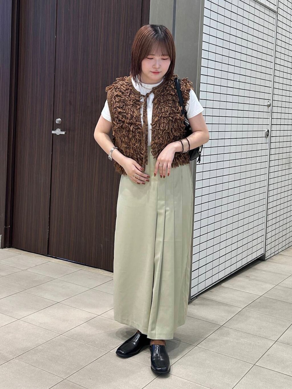 ホワイト系のTシャツ/カットソー、ブラウン系のベスト、ブラック系のボストンバッグを着用したレディースの夏コーディネートの5枚目の写真