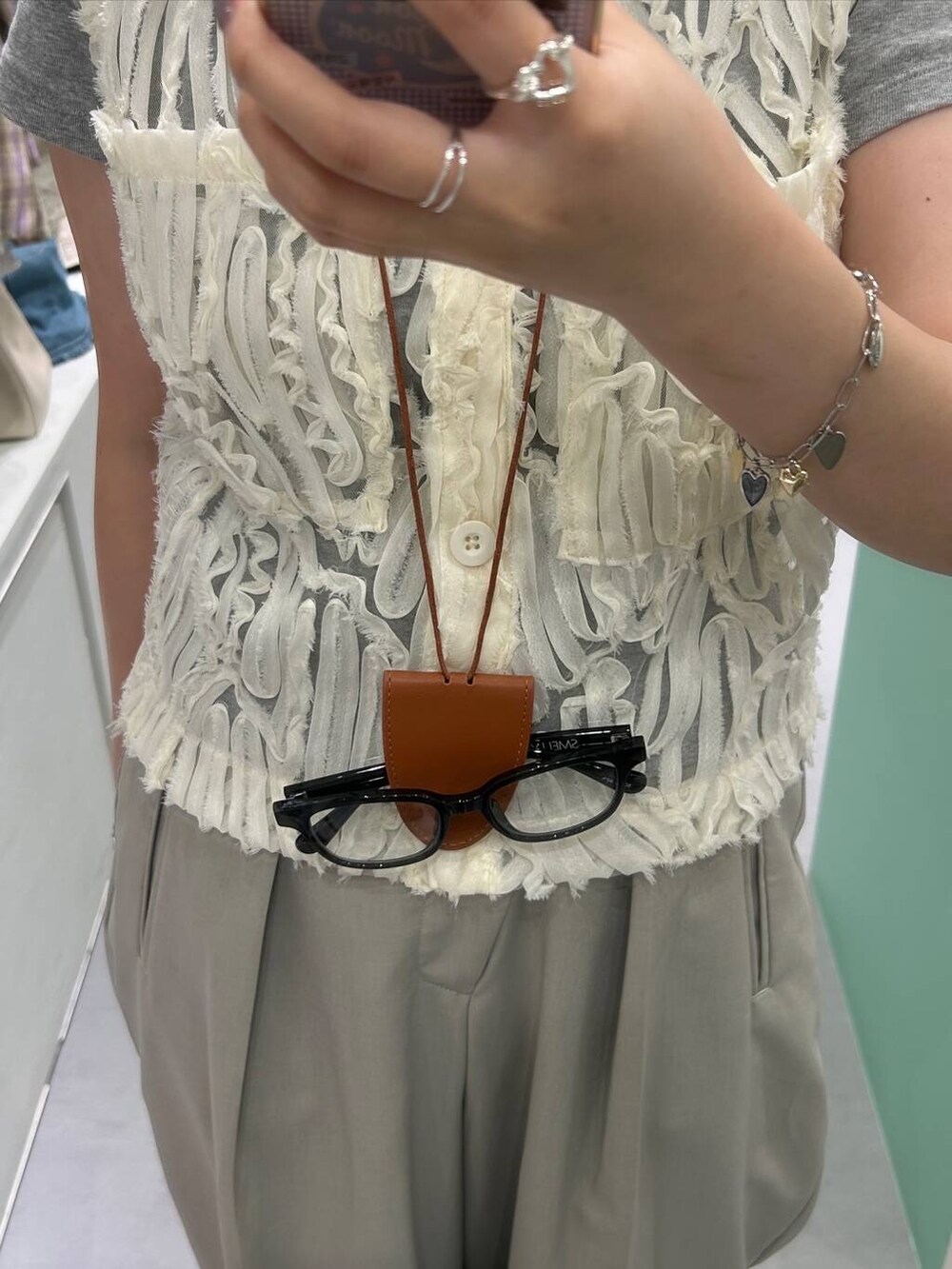 ブラック系のメガネ、シルバー系のブレスレット、シルバー系のリングを着用したレディースの夏コーディネートの2枚目の写真