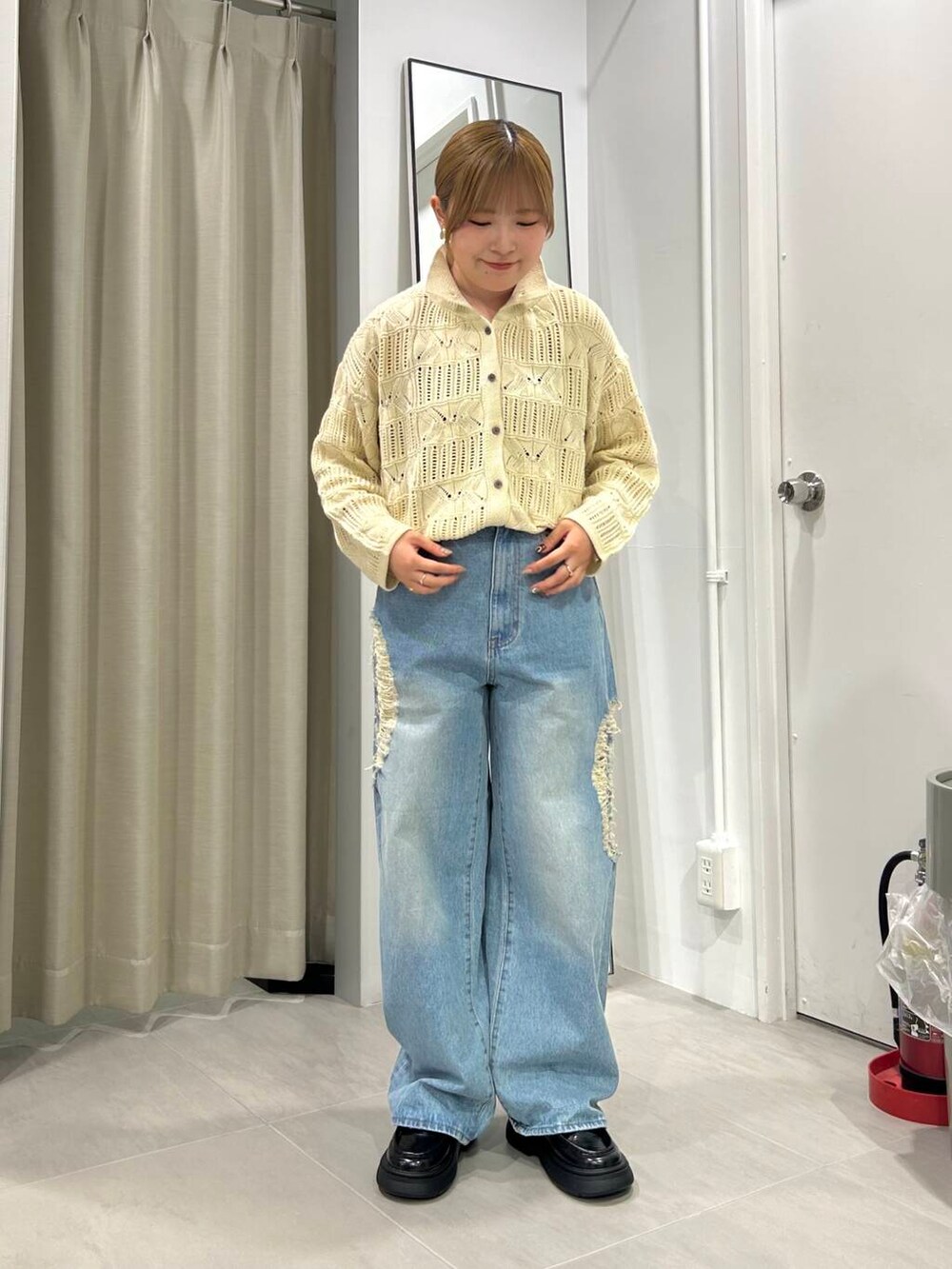 ブルー系のデニムパンツ、ブラック系のローファー、ホワイト系のカーディガン/ボレロを着用したレディースの秋コーディネートの3枚目の写真