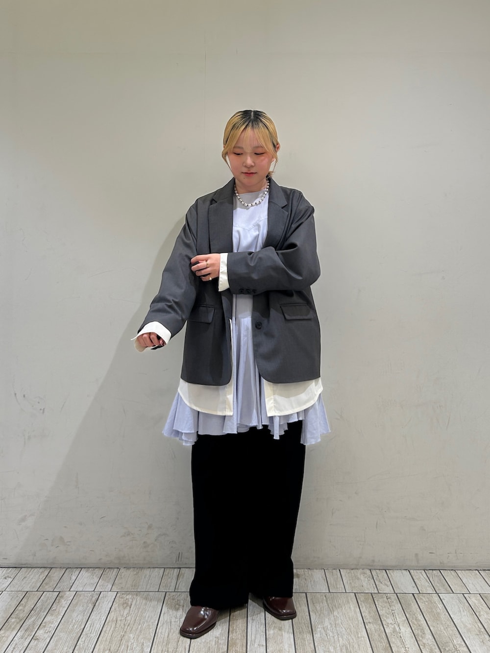 ブラック系のデニムパンツ、グレー系のその他アウター、ブルー系のワンピースを着用したレディースの冬コーディネートの2枚目の写真