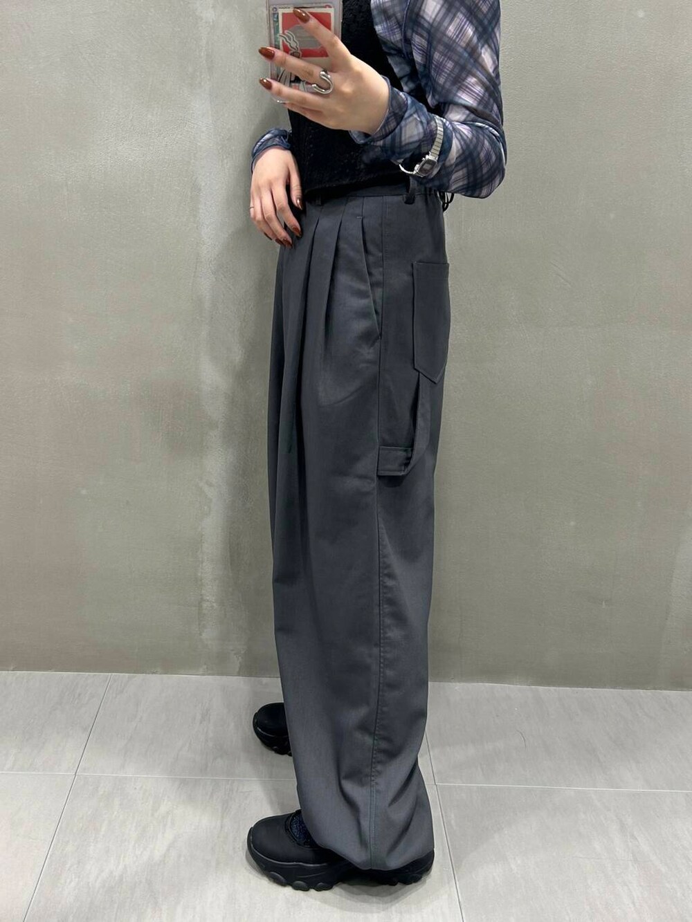 ブラック系のスニーカー、グレー系のスラックス、ブラック系のその他トップスを着用したレディースの秋コーディネートの6枚目の写真