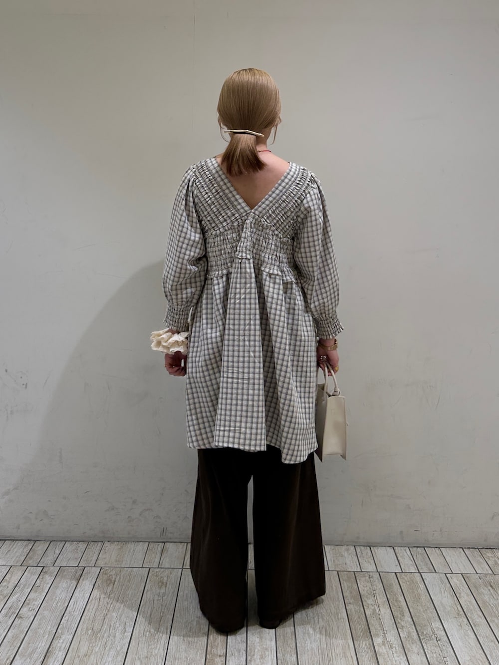 ベージュ系のワンピース、ホワイト系のハンドバッグ、ブラウン系のその他パンツを着用したレディースの春コーディネートの5枚目の写真