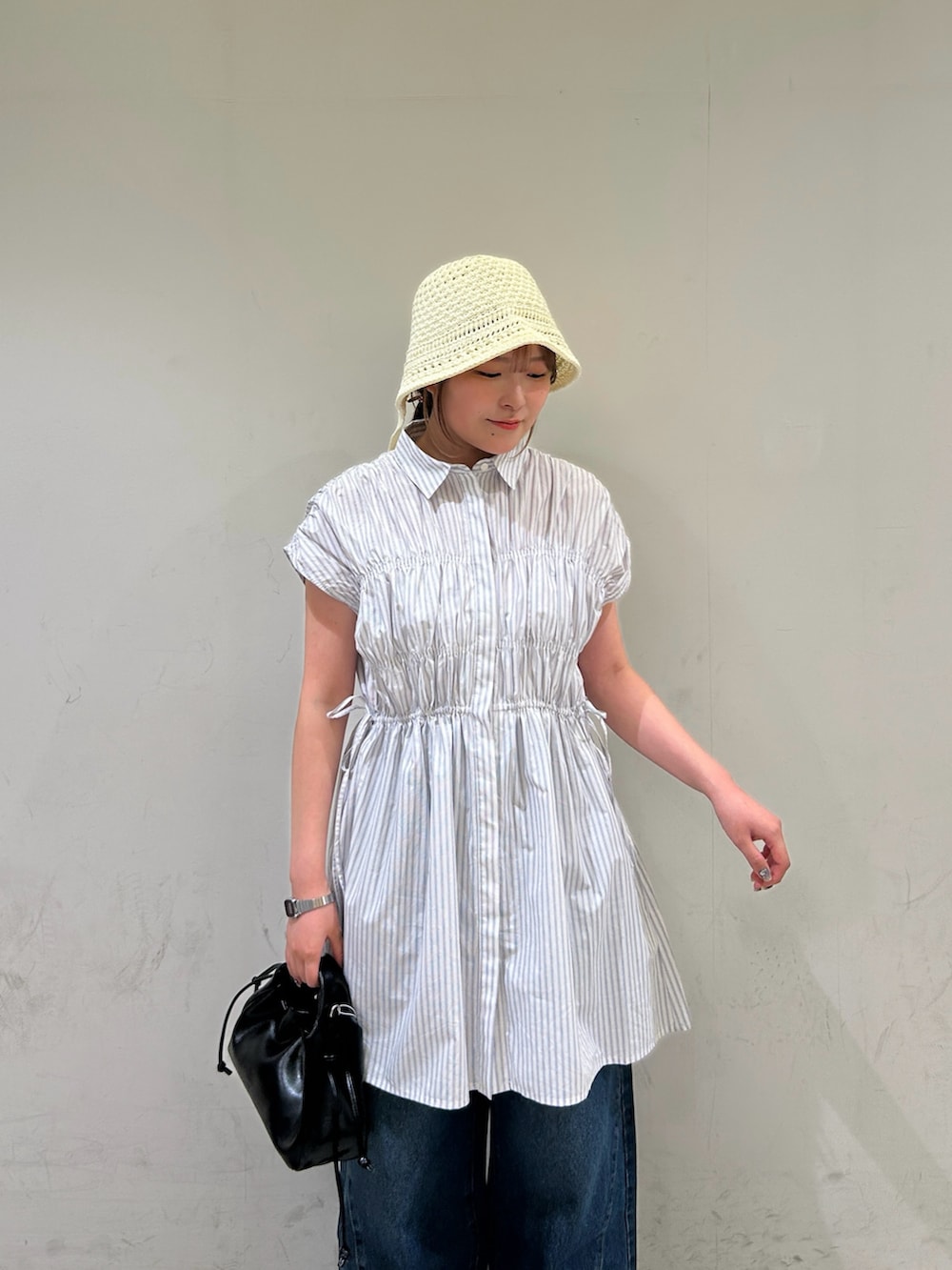 ホワイト系のワンピース、ブルー系のデニムパンツ、ホワイト系のサンダルを着用したレディースの夏コーディネートの4枚目の写真