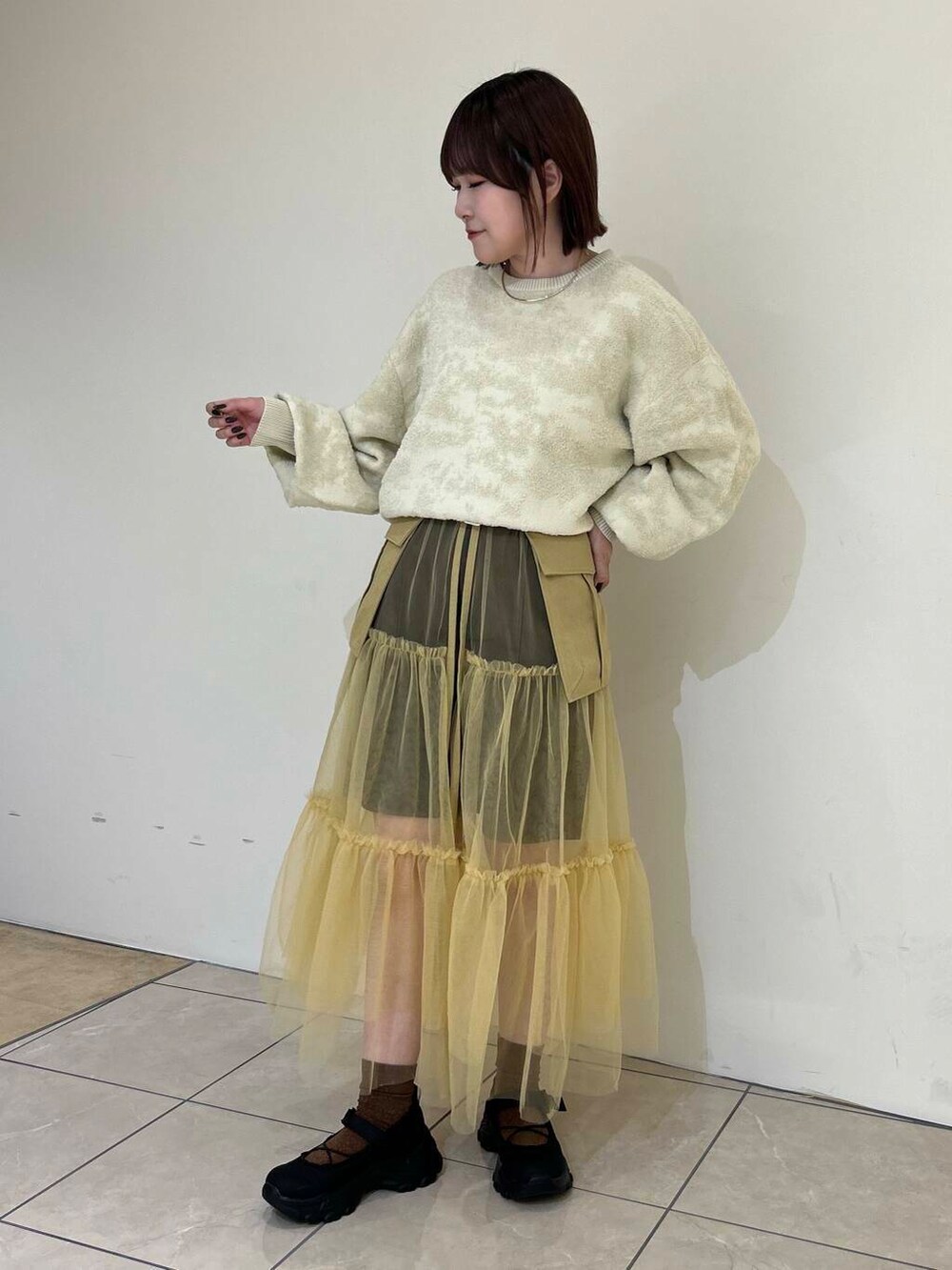 ブラック系のスニーカー、ベージュ系のスカート、ブラウン系のその他パンツを着用したレディースの夏コーディネートの4枚目の写真