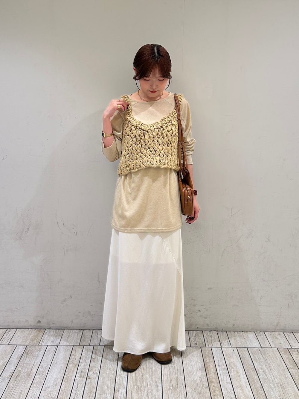 ベージュ系のTシャツ/カットソー、ベージュ系のニット/セーター、ホワイト系のスカートを着用したレディースの秋コーディネートの2枚目の写真