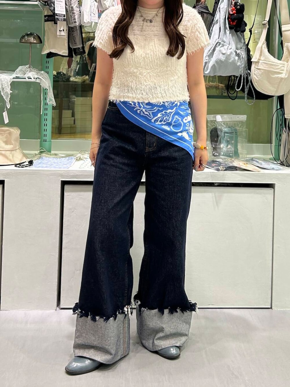 ブルー系のデニムパンツ、イエロー系のニット/セーター、シルバー系のネックレスを着用したレディースの春コーディネートの5枚目の写真