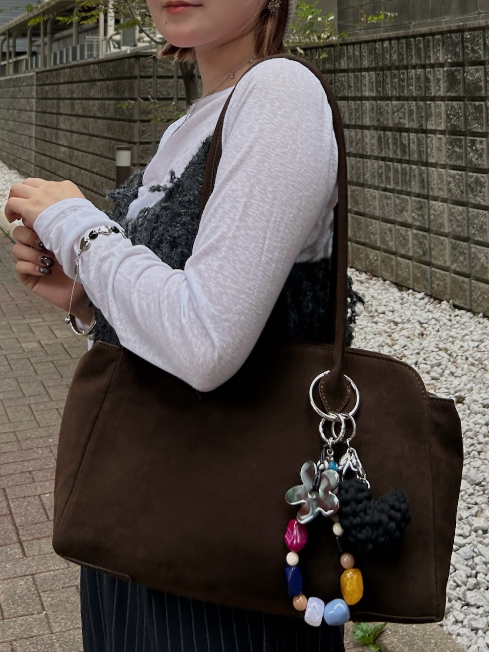 グレー系のその他トップス、ブラック系のスニーカー、ブラウン系のボストンバッグを着用したレディースの秋コーディネートの5枚目の写真