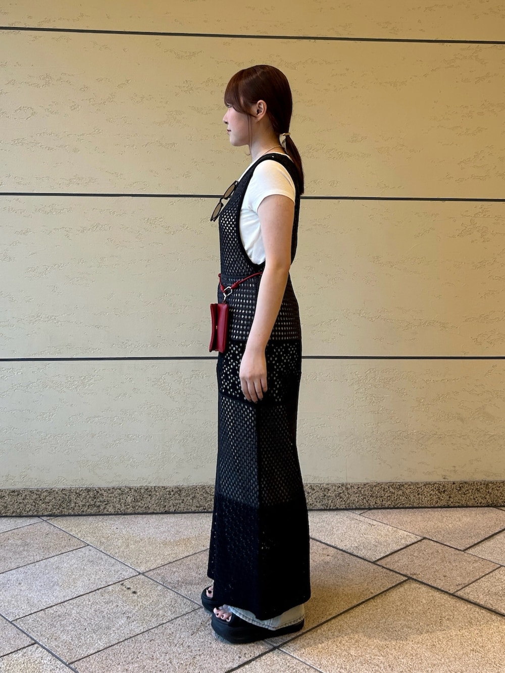 グレー系のワンピース、ホワイト系のTシャツ/カットソー、ブルー系のデニムパンツを着用したレディースの夏コーディネートの2枚目の写真