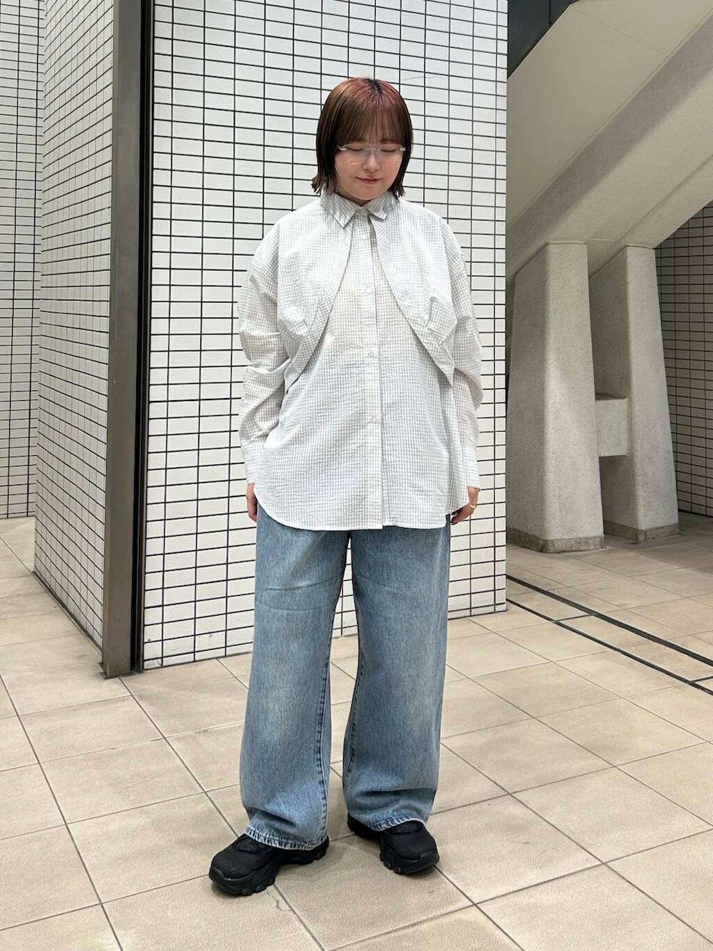 ブルー系のデニムパンツ、ブラック系のスニーカー、レッド系のショルダーバッグを着用したレディースの冬コーディネートの5枚目の写真