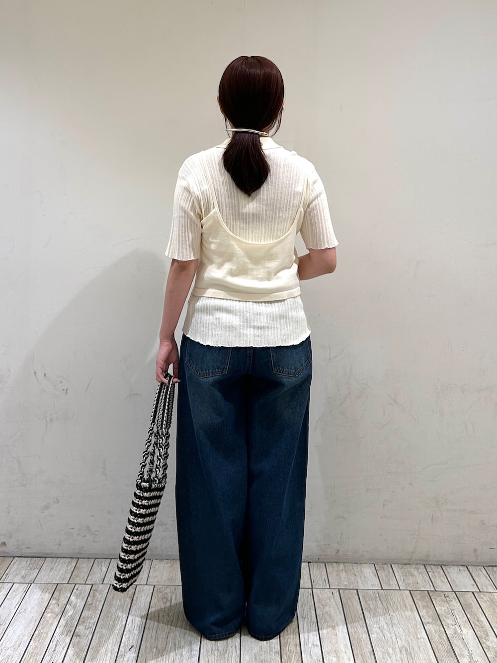 ホワイト系のニット/セーター、ブルー系のデニムパンツ、シルバー系のサンダルを着用したレディースの夏コーディネートの4枚目の写真