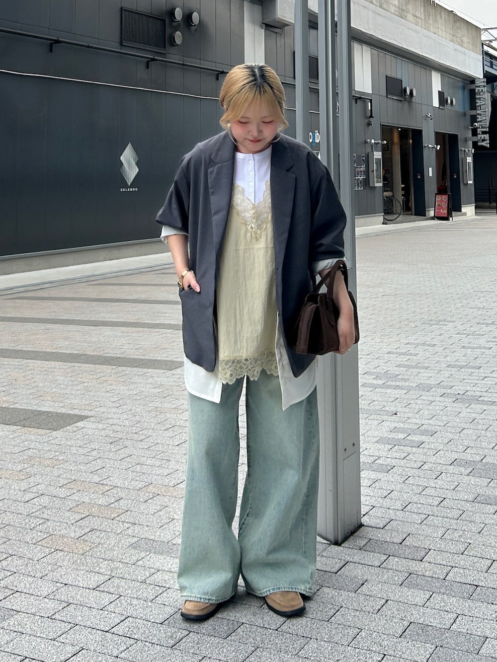 グレー系のその他アウター、ブルー系のデニムパンツ、ベージュ系のローファーを着用したレディースの春コーディネートの2枚目の写真