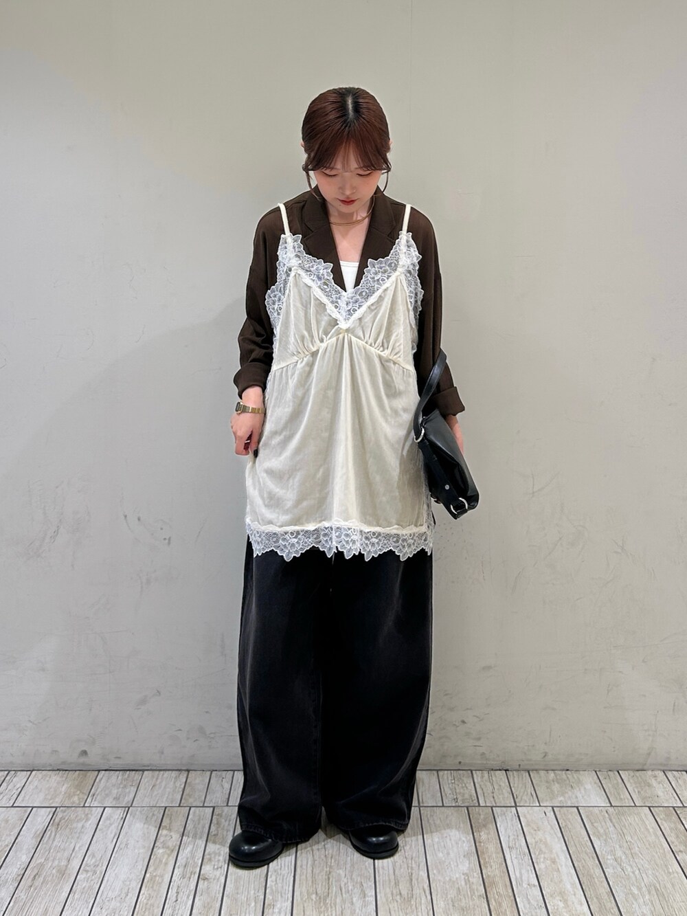 ブラック系のデニムパンツ、ブラック系のサンダル、ブラック系のショルダーバッグを着用したレディースの秋コーディネートの2枚目の写真