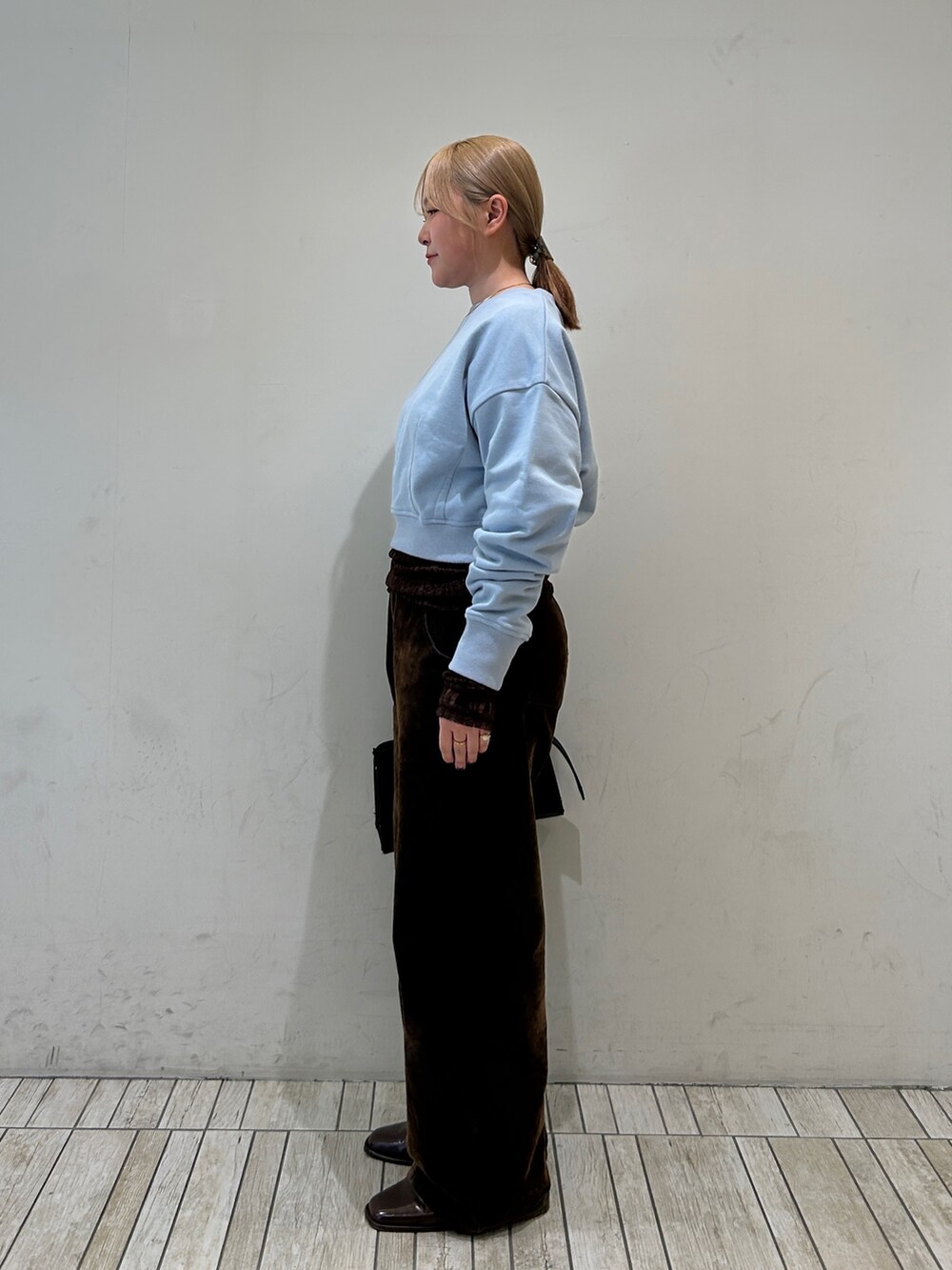 ブラウン系のデニムパンツ、ブラウン系のTシャツ/カットソー、ブラック系のボストンバッグを着用したレディースの春コーディネートの2枚目の写真