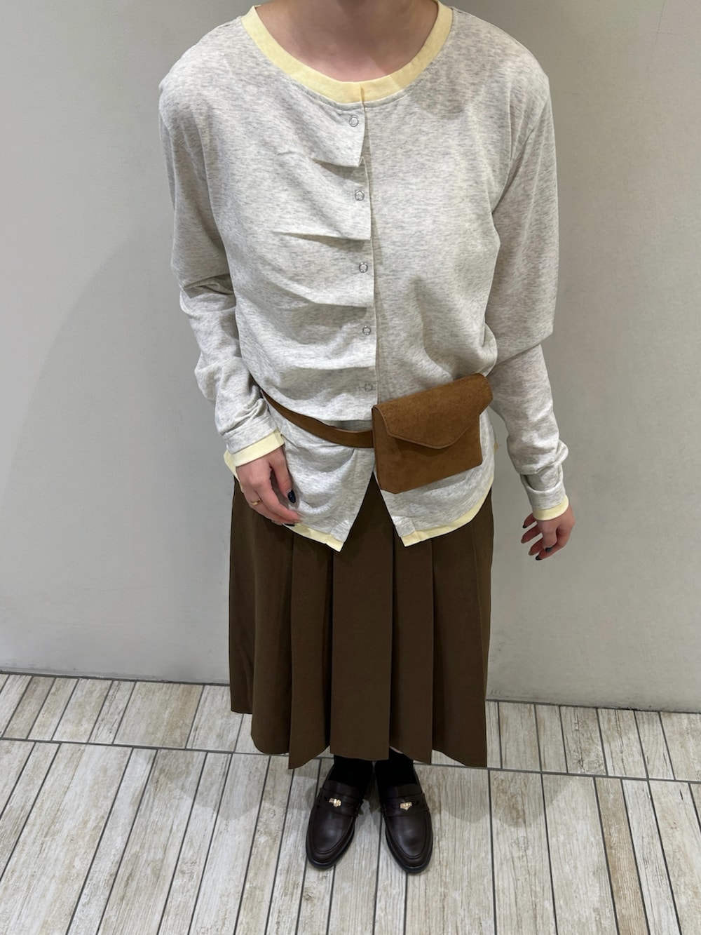 ベージュ系のTシャツ/カットソー、イエロー系のボディバッグ/ウエストポーチ、ブラウン系のスカートを着用したレディースの秋コーディネートの5枚目の写真