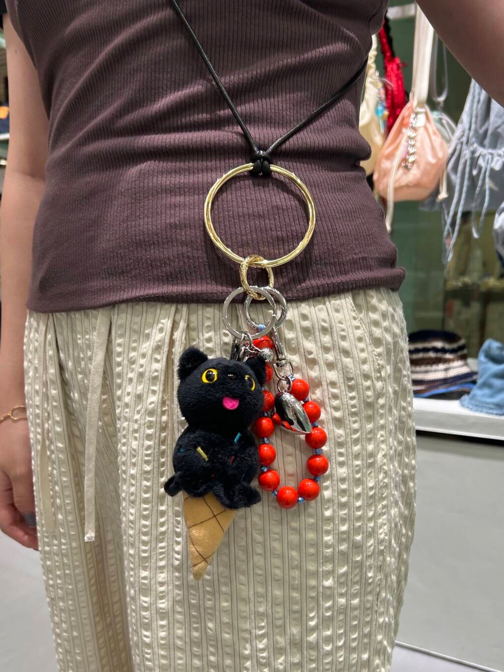 ベージュ系のその他パンツ、レッド系のキーホルダー、ブラック系のキーホルダーを着用したレディースの夏コーディネートの3枚目の写真
