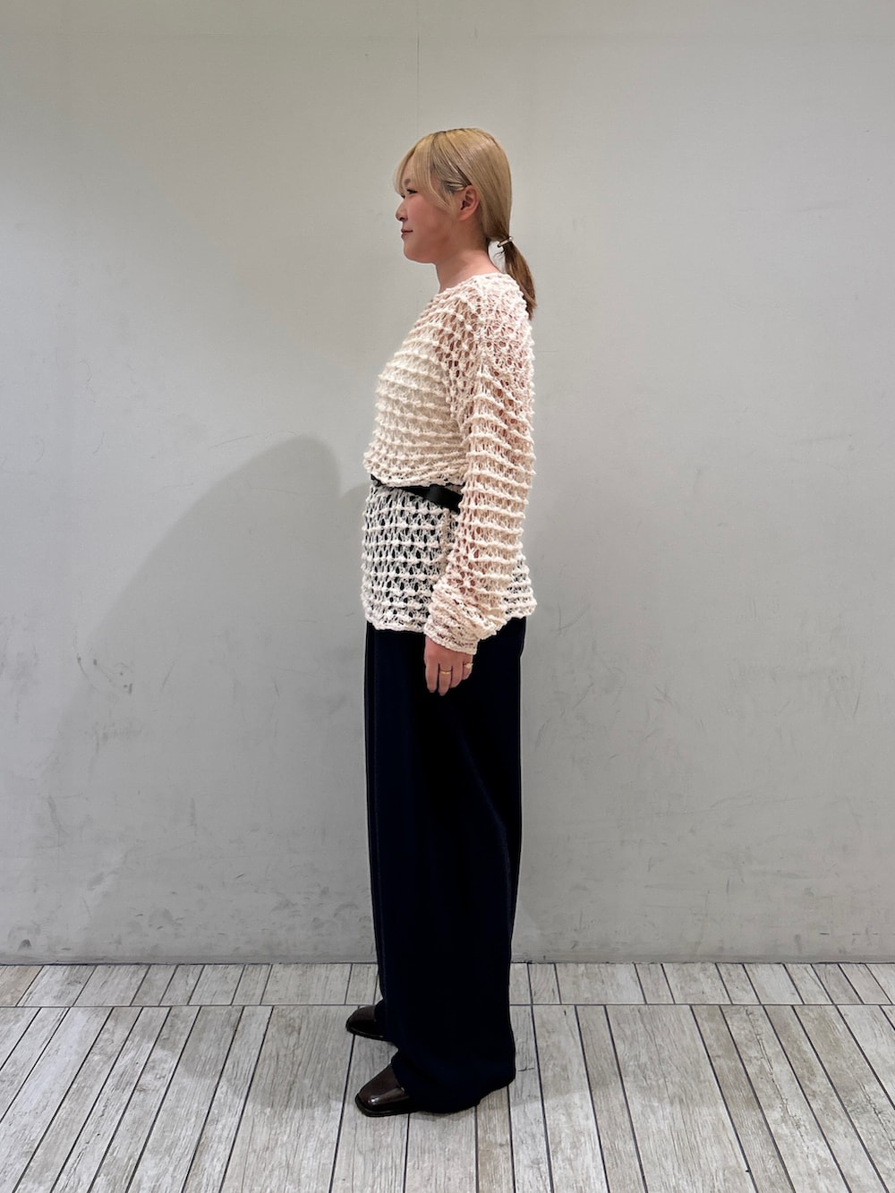 ホワイト系のニット/セーター、ブルー系のその他パンツ、ブラック系のベルトを着用したレディースの春コーディネートの2枚目の写真