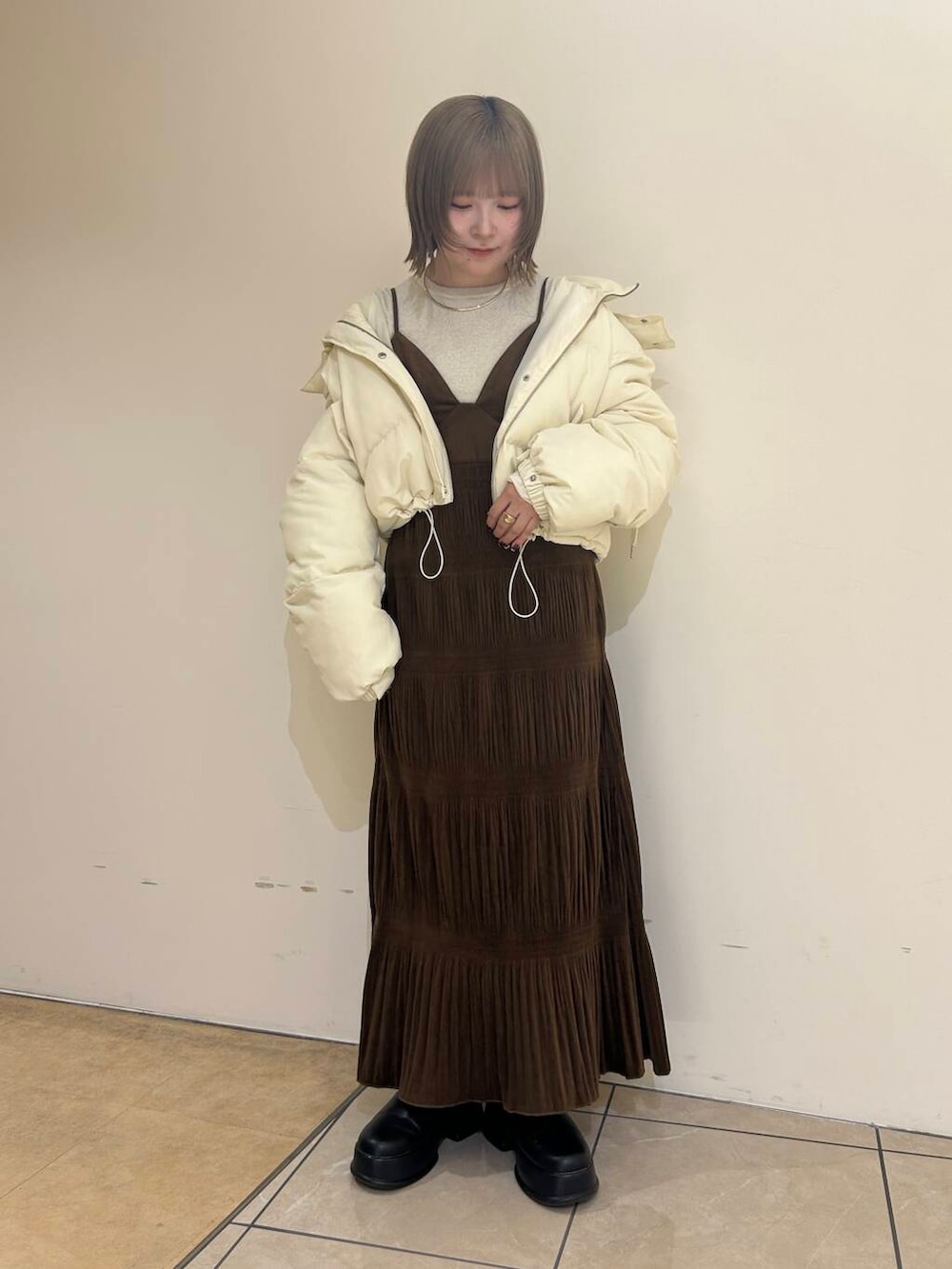 ホワイト系のダウンジャケット/コート、ブラウン系のワンピース、ホワイト系のニット/セーターを着用したレディースの冬コーディネートの3枚目の写真