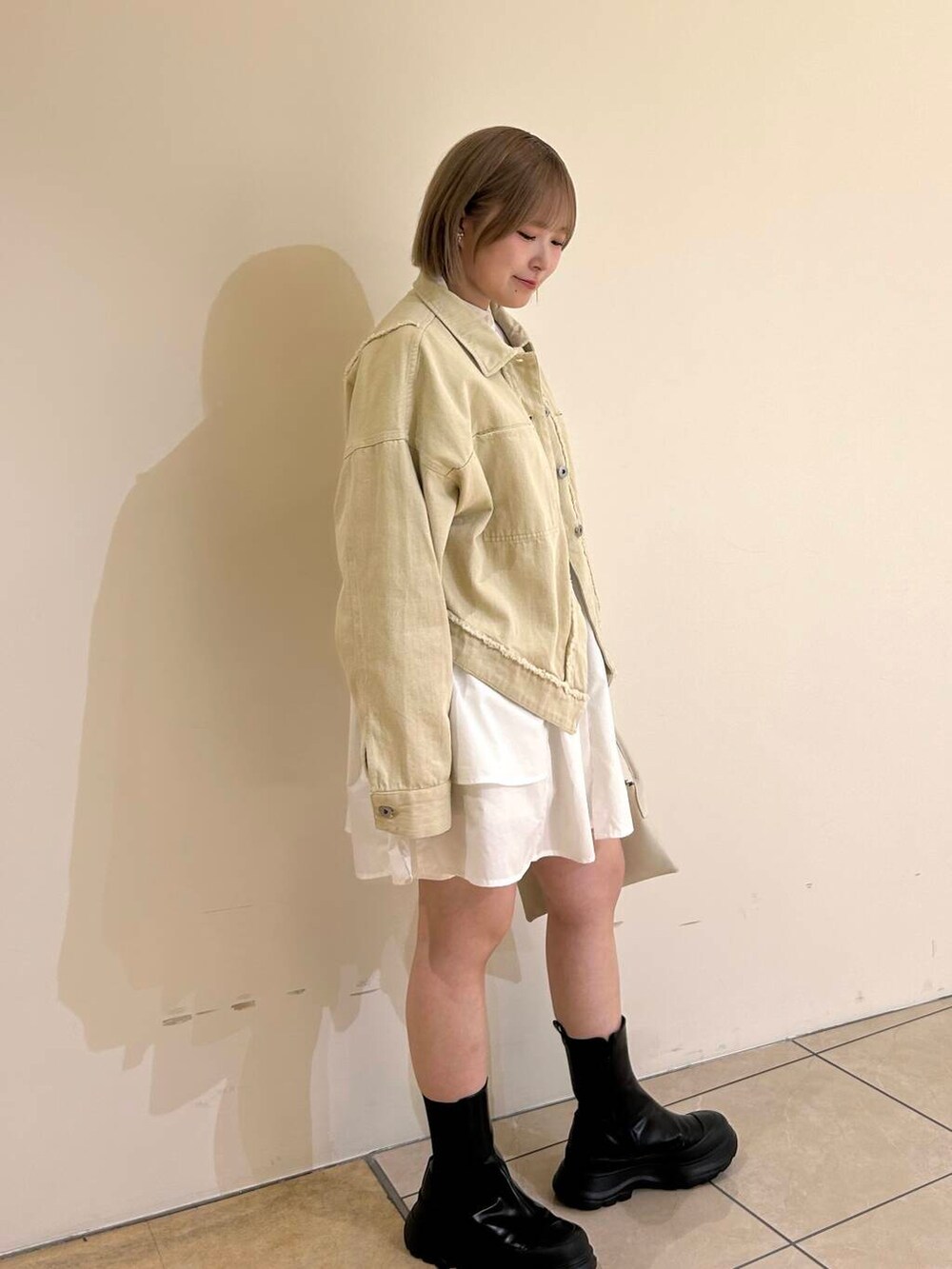 ホワイト系のワンピース、ホワイト系のショルダーバッグ、ホワイト系のカバーオールを着用したレディースの秋コーディネートの3枚目の写真